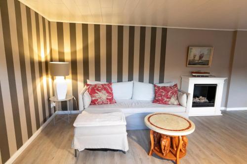 un soggiorno con un divano bianco e un tavolo di Ferienwohnung Captains Lodge Steinbergkirche a Steinbergkirche