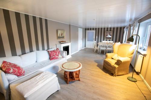 un soggiorno con divano bianco e sedia di Ferienwohnung Captains Lodge Steinbergkirche a Steinbergkirche