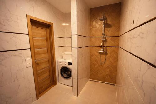 a bathroom with a washing machine and a washer at Modern Smart Apartment, Garage & City View in Lipany