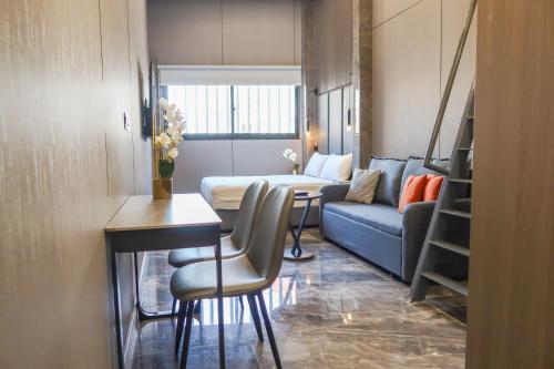 een woonkamer met een bank en een tafel bij RR Studios & Suites in Singapore