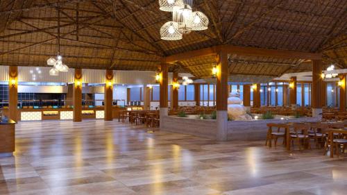 een grote kamer met tafels en stoelen en een fontein bij JAZ Adonia in Uroa