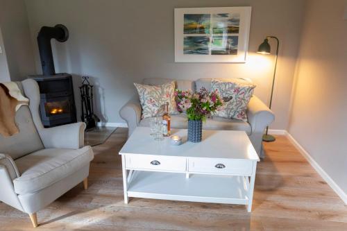 een woonkamer met een witte salontafel met bloemen erop bij Ferienwohnung Backbord Steinbergkirche in Steinbergkirche