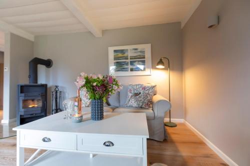 een woonkamer met een witte salontafel met bloemen erop bij Ferienwohnung Backbord Steinbergkirche in Steinbergkirche