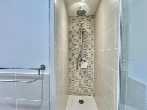 een badkamer met een douche met een glazen deur bij Occitemps in Saint Julien Les Rosiers