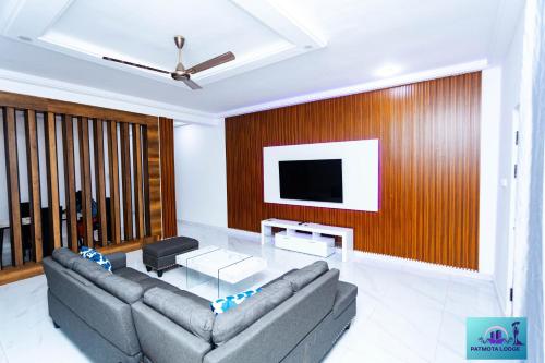 un soggiorno con un divano e una TV di Ernest homes a Kwabenyan