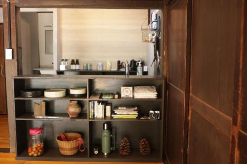 ein Bücherregal mit Gegenständen auf einem Zimmer in der Unterkunft BoBuchi in Ichihara