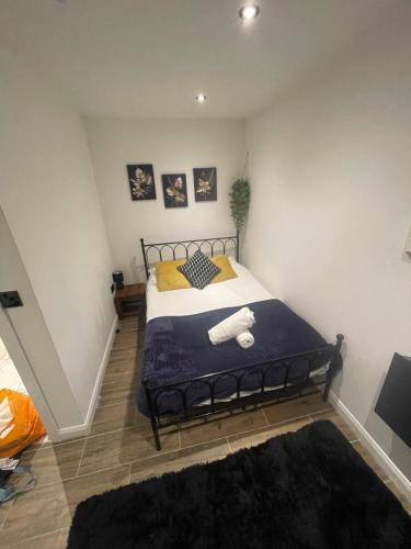 una camera da letto con un letto con una coperta blu e cuscini gialli di The Cotes Suite by Nestura a Loughborough