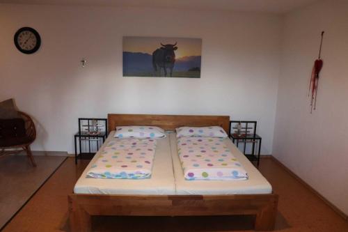 two beds in a room with a picture of a cow on the wall at Ferienwohnung Bio-Bauernhof Schuwerk in Isny im Allgäu