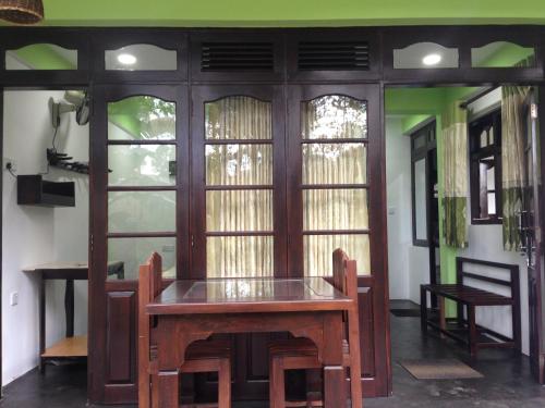 a dining room with a table and some windows at Villa Eden Paradise in Ella