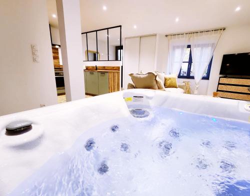 eine große weiße Badewanne in einem Zimmer in der Unterkunft L'échappée Bulles - T3 - Jacuzzi in Auch