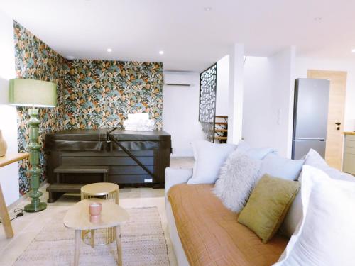 ein Wohnzimmer mit einer Couch und einem Klavier in der Unterkunft L'échappée Bulles - T3 - Jacuzzi in Auch