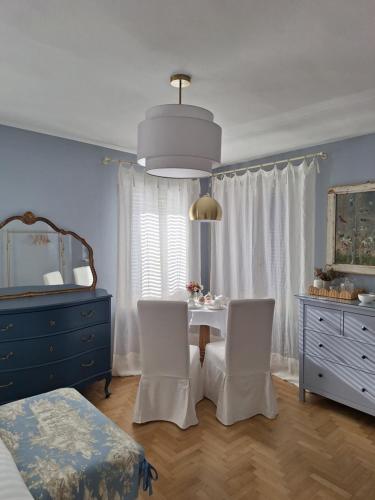 ein Schlafzimmer mit einem Tisch, 2 Stühlen und einer Kommode in der Unterkunft al piccolo giardino in Vittorio Veneto