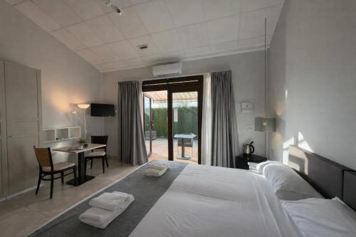 ein Schlafzimmer mit einem großen weißen Bett und einem Tisch in der Unterkunft Hotel Xabina Javea in Jávea