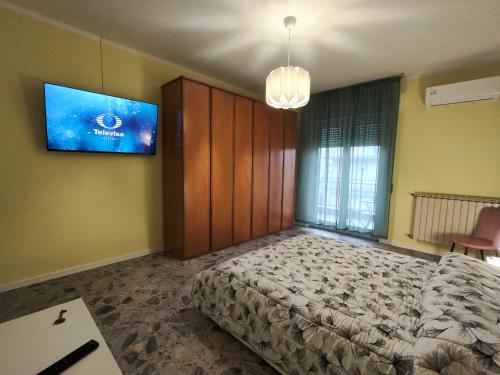 ein Schlafzimmer mit einem Bett und einem Fernseher an der Wand in der Unterkunft Attico Stadio in Pescara