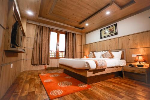 een slaapkamer met een bed en een televisie in een kamer bij Yangthang Heritage in Gangtok