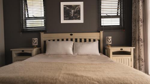 a bedroom with a large bed with two night stands at Essea House in Wilderness