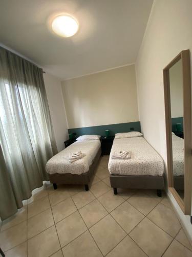 a room with two twin beds and a mirror at B&B Ramses in Uta
