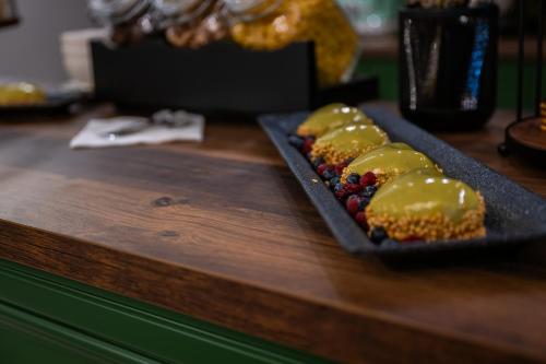 ein schwarzer Teller mit Lebensmitteln auf einem Holztisch in der Unterkunft RUELLE Chateau Boutique in Sinaia