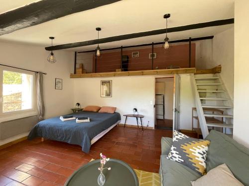 a bedroom with a bed and a staircase in a room at MAS-Calou in Coustellet