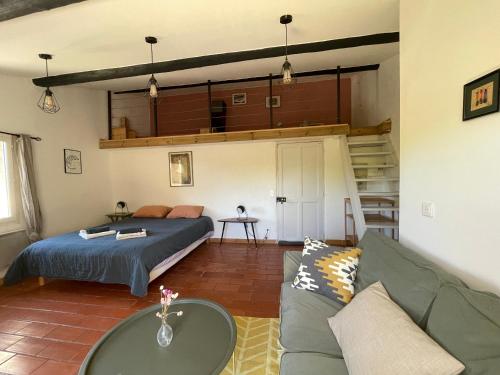 a living room with a bed and a couch at MAS-Calou in Coustellet