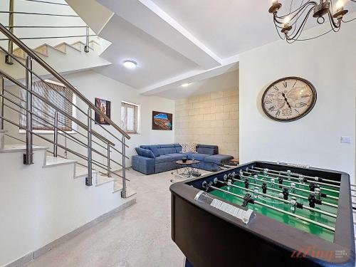 a living room with a pool table and a clock at Peaceful Home with Private Pool and Rooftop Jacuzzi in Xagħra
