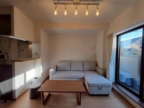 ein Wohnzimmer mit Sofa und Tisch in der Unterkunft In time tokyo in Ichikawa