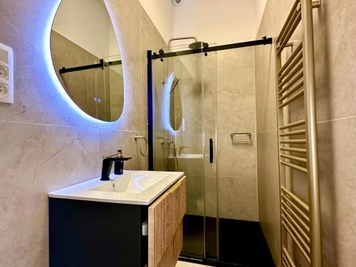 a bathroom with a sink and a shower with a mirror at Luxury Suites Royal by Rikas Hotels in Antwerp