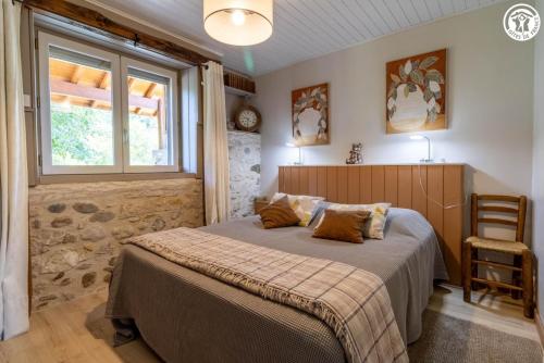 ein Schlafzimmer mit einem Bett, einem Fenster und einem Stuhl in der Unterkunft La grange du paris in Saint-Pierre-dʼAlvey