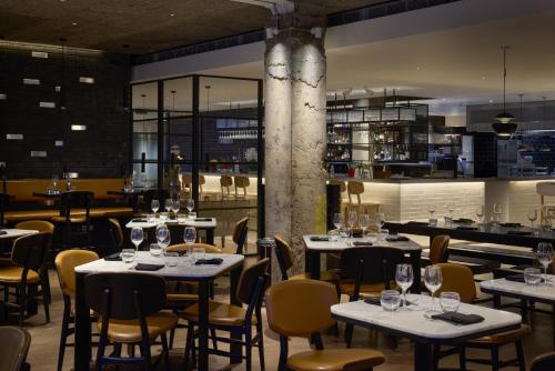 a restaurant with tables and chairs with wine glasses at Radisson Blu Hotel, London Leicester Square in London