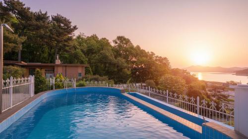 a swimming pool in front of a house at Ganghwa Giverny Spa Pension in Incheon
