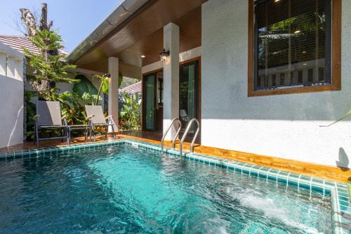 a swimming pool in front of a house at Naiyang Park Resort - SHA Extra Plus in Nai Yang Beach