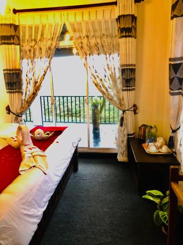 a bedroom with a bed and a large window at Top view cottage in Nuwara Eliya