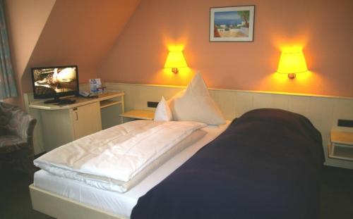 a bedroom with a bed with two lamps on the wall at Zum treuen Bartel in Markgröningen