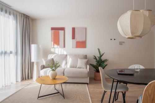a living room with a couch and a table at Líbere Seville Plaza Nueva in Seville
