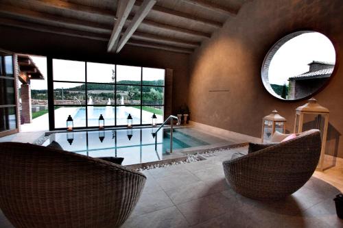 a pool room with two chairs and a mirror at Casa Rural Cirera D'Avall in Lladurs