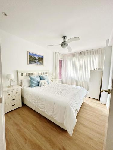 een witte slaapkamer met een groot bed met blauwe kussens bij Mundaka Centre 2 in Mundaka