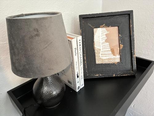 een lamp op een tafel naast een boek en een schilderij bij Courtyard Pool Studio Private Luxe Retreat in Coal Point