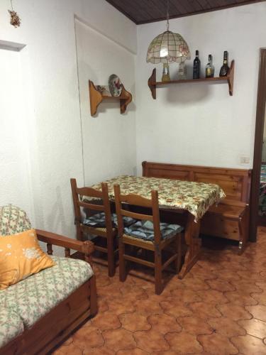 - une salle à manger avec une table, des chaises et un canapé dans l'établissement Le Conifere Garden Residence, à Filettino