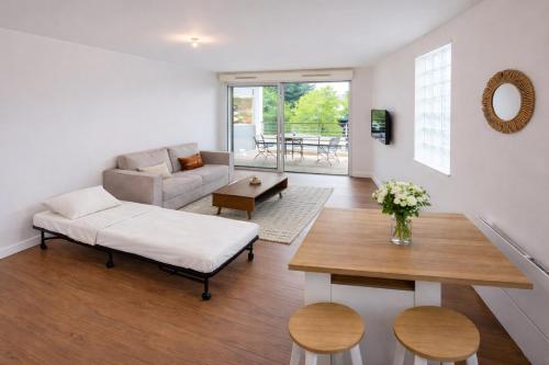 un soggiorno con un divano e un tavolo di Vaste studio 3 personnes avec balcon et parking a La Teste-de-Buch