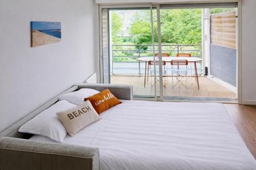 una camera da letto con un letto e un balcone con un tavolo di Vaste studio 3 personnes avec balcon et parking a La Teste-de-Buch