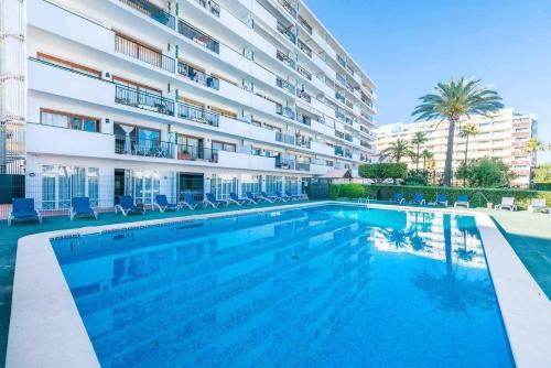 a swimming pool in front of a building at NEW Apt Relax Home a 150 m del mar, WIFI y Piscina in Port d'Alcudia