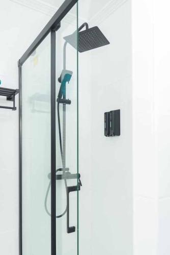 a shower with a glass door with a hair dryer at NEW Apt Relax Home a 150 m del mar, WIFI y Piscina in Port d'Alcudia