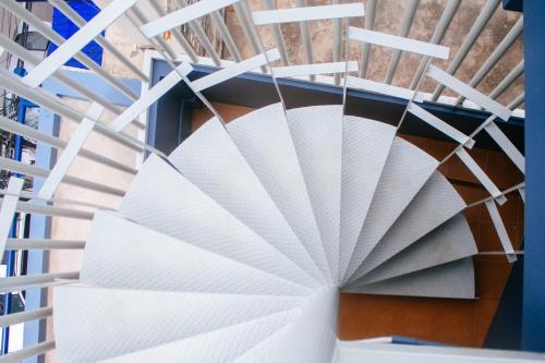 a spiral staircase in a building with white paper at The Moon Hostel Huahin in Hua Hin