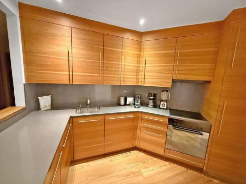 een keuken met houten kasten en een spoelbak bij Lusso nel cuore di Sankt Moritz in St. Moritz