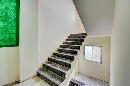 a staircase in a building with a green window at Via Pink House in Pune