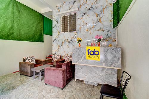 a room with a table and chairs and a green wall at Via Pink House in Pune