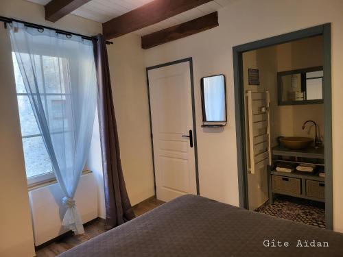una camera con un letto, una porta e una finestra di Le Gite Aïdan a La Puye