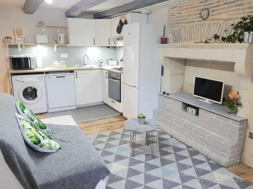 un soggiorno con divano e cucina di Le Gite Leiloo a La Puye