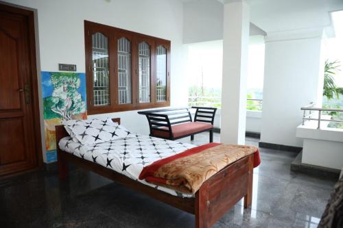 a bedroom with a bed and a chair in a room at A CLASS King bedroom with balcony view, extra bed, and a spacious bathroom with changing area in Chakkarakkal
