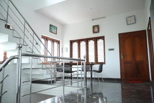 a table and chairs in a room with stairs at A CLASS King bedroom with balcony view, extra bed, and a spacious bathroom with changing area in Chakkarakkal